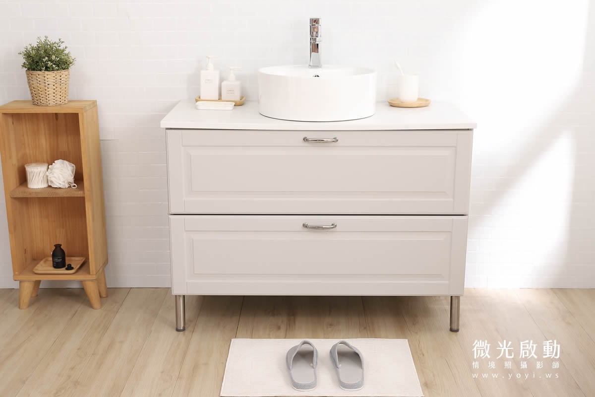 特寫：攝影棚浴室場景洗手台與浴櫃近景，淺米色雙抽屜櫃體，搭配白色圓形面盆，適合衛浴設備特寫